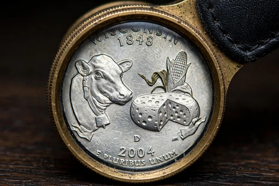 2004-D Wisconsin quarter under a magnifying loupe showing the Extra Leaf variety on the corn husk — worth $50 to $6,000